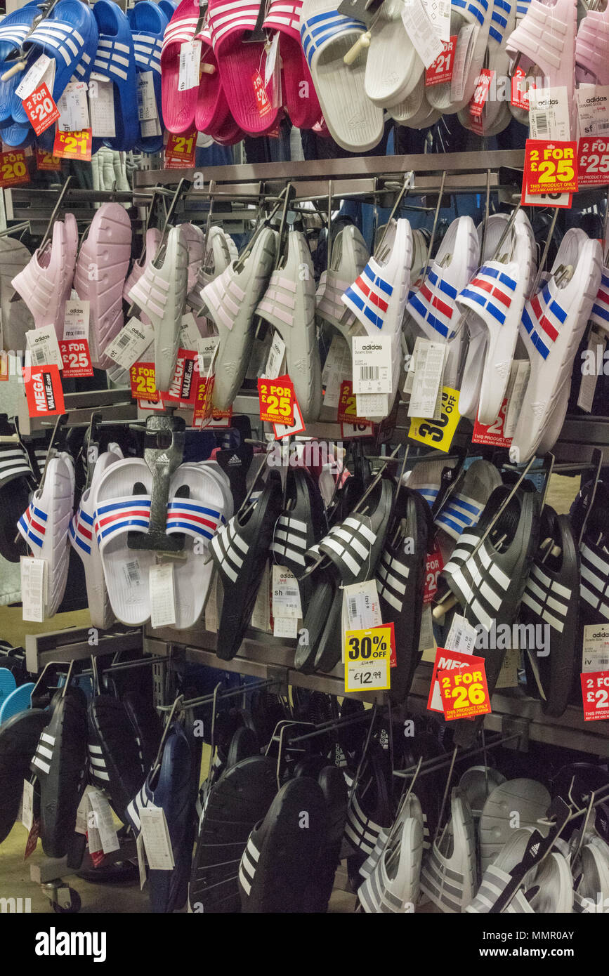 Una selezione di scarpe da ginnastica e flip flop scarpe in vendita presso  una delle principali attrezzature sportive e rivenditore di abbigliamento  sulla strada alta Foto stock - Alamy