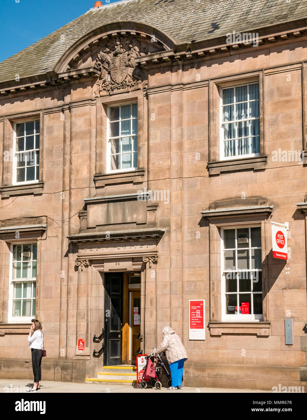 Haddington Post Office frontage, edificio storico, Court Street, East Lothian, Scozia, Regno Unito con la giovane donna e donna disabile Foto Stock