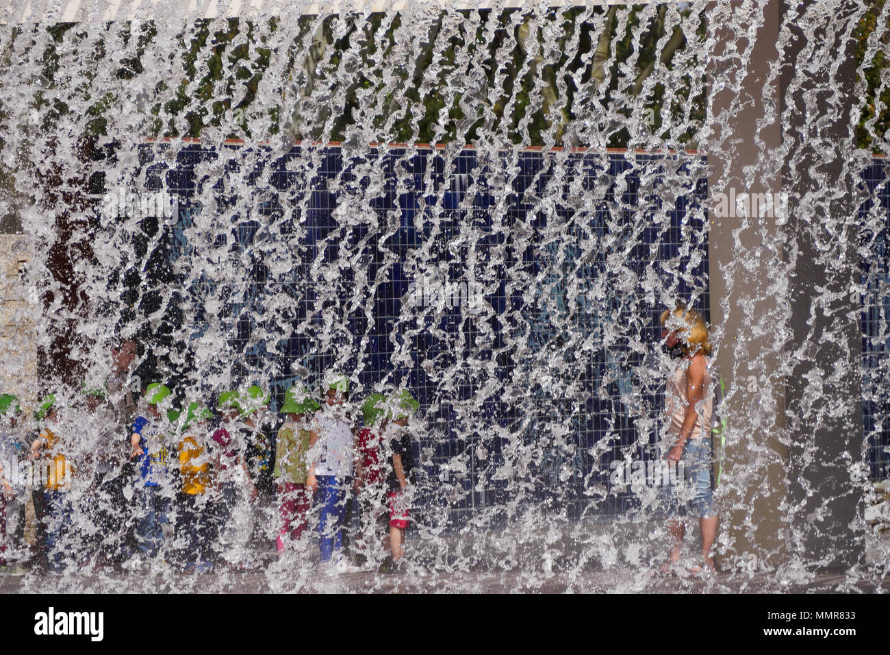 Persone in piedi dietro una cortina di acqua, nel Parco delle Nazioni district, Lisbona, Portogallo Foto Stock