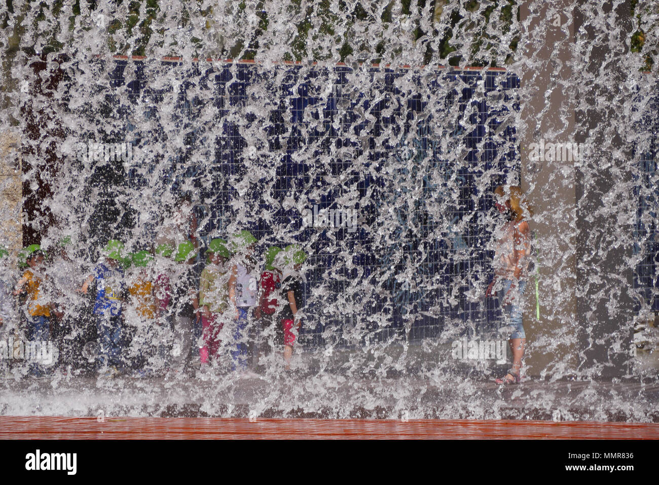 Persone in piedi dietro una cortina di acqua, nel Parco delle Nazioni district, Lisbona, Portogallo Foto Stock