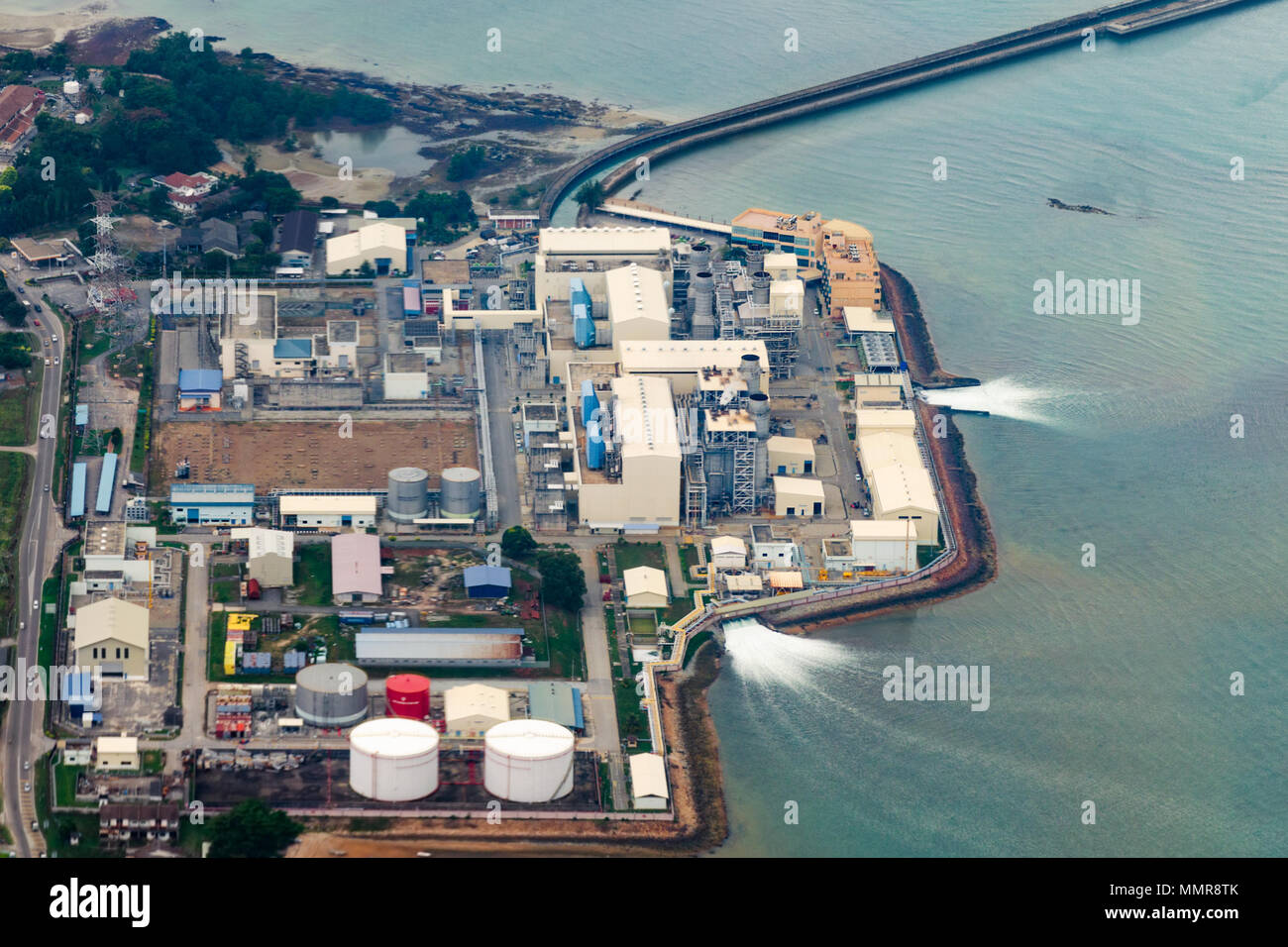 Vista aerea di un impianto industriale che utilizza acqua di mare e lo restituisce all'indietro. Uso di risorse naturali e l'inquinamento idrico. Malaysia Petronas. Foto Stock