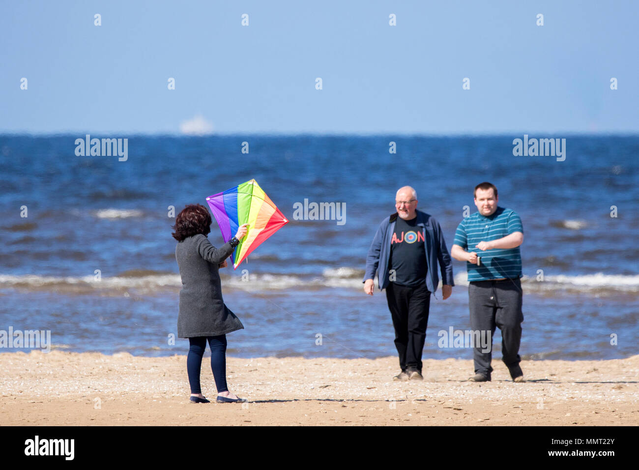 Southport, Merseyside. 13 maggio 2018. Regno Unito Meteo. Una donna ha il grande divertimento cerca di catturare il suo kite sulle sabbie dorate della spiaggia di Southport nel Merseyside. Credito: Cernan Elias/Alamy Live News Foto Stock
