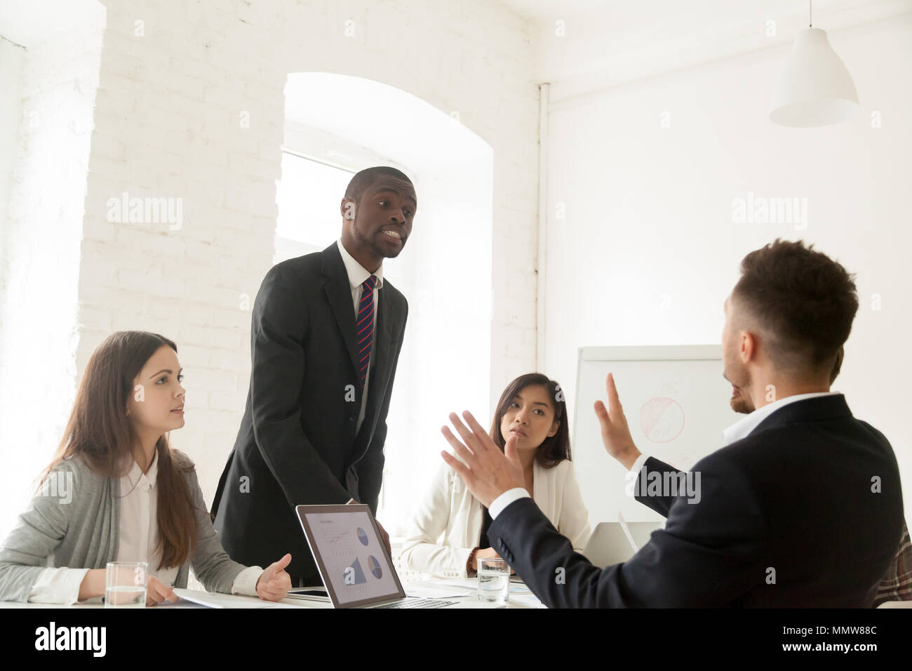 Rude arrabbiato imprenditore africana sostenendo le grida al collega dur Foto Stock