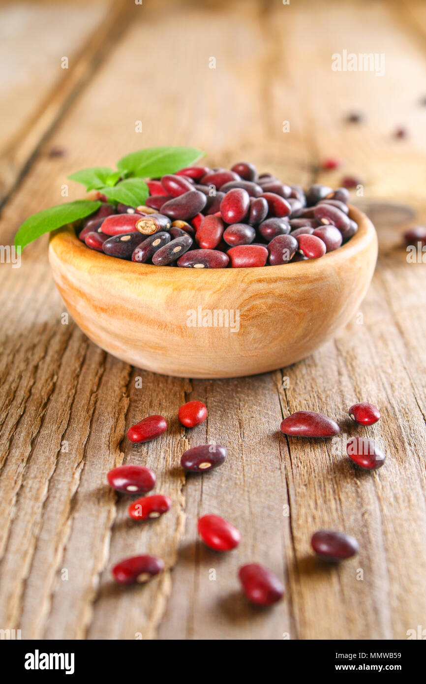 Red raw con fagioli verdi su un tavolo di legno Foto Stock