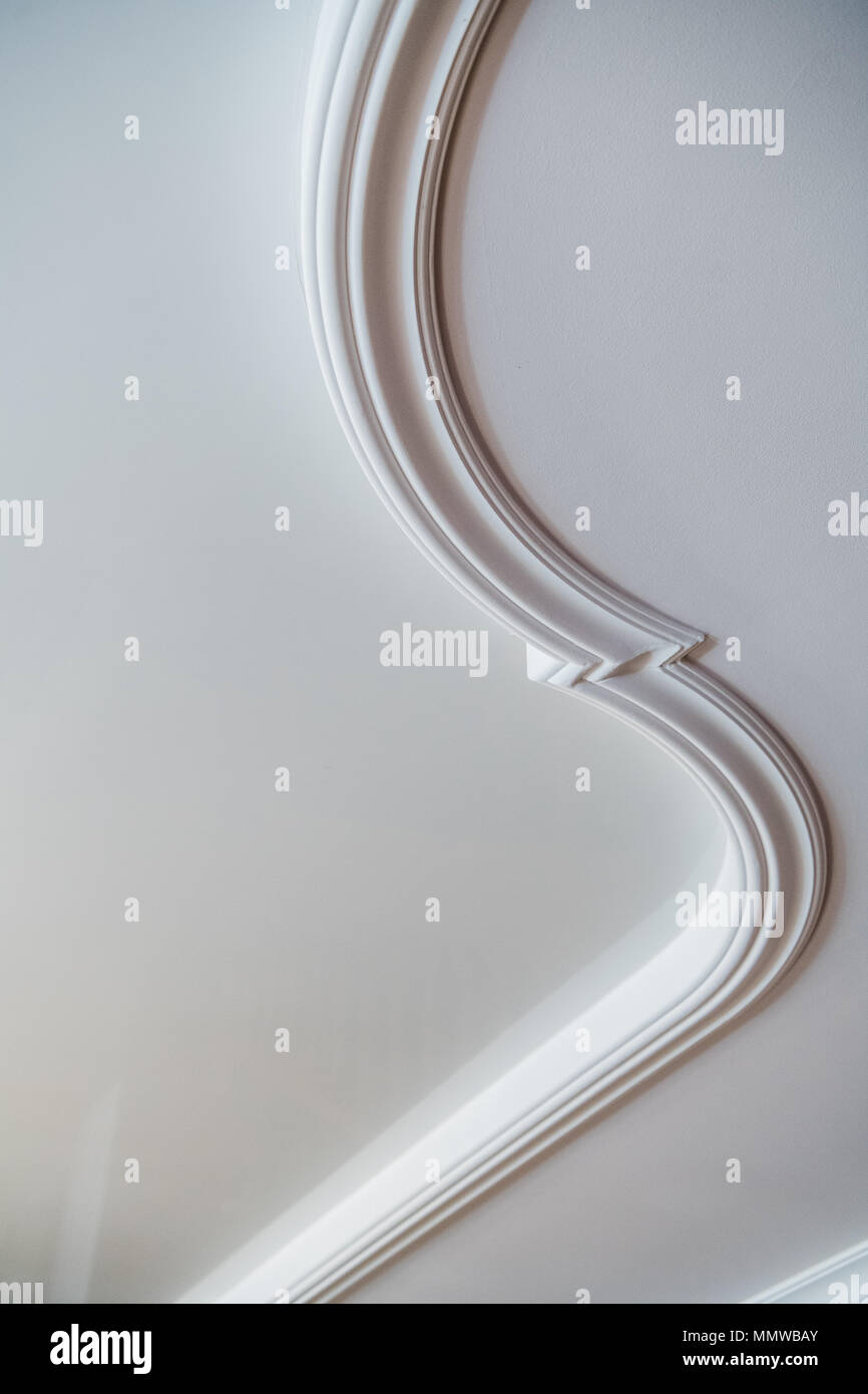 Curva di argilla di decorazione in stucco di stampaggio in rilievo sul soffitto bianco in astratto stile classico interno Foto Stock