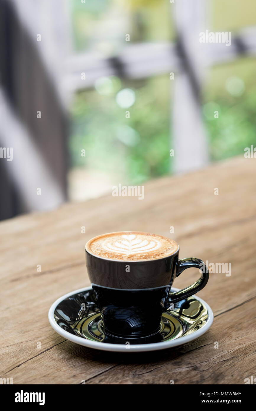 Cappuccino calda tazza di caffè con forma ad albero latte art schiuma di  latte sul tavolo