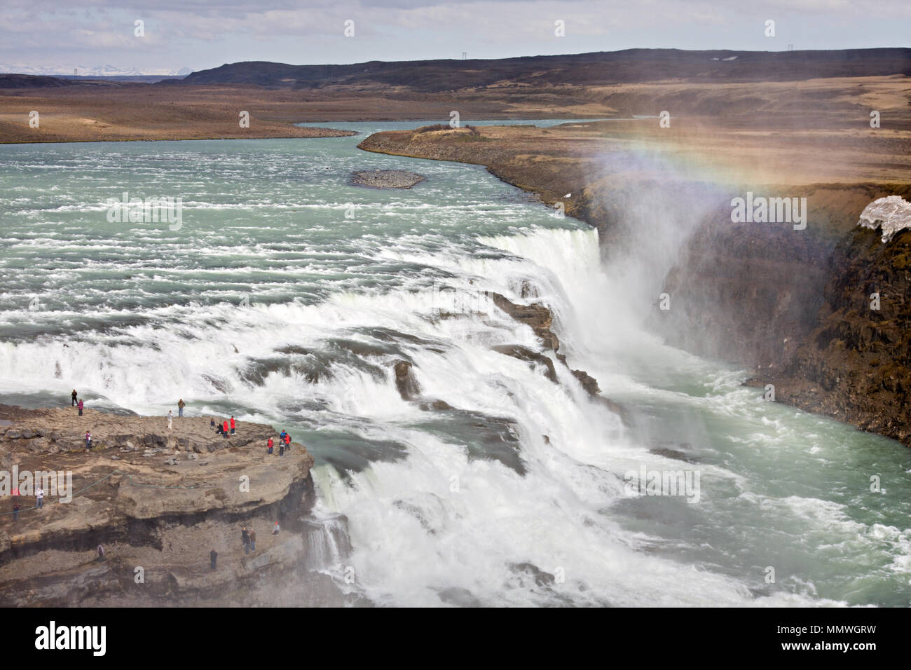 La parte superiore della cascata gigantesca Gullfoss in Islanda con molto piccola in cerca di turisti. Foto Stock