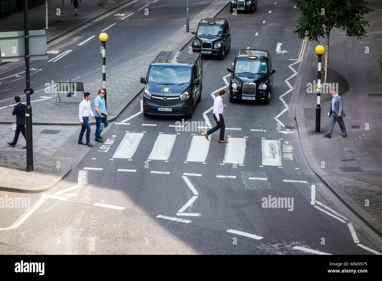 Le persone che attraversano la strada in corrispondenza di un incrocio di zebra sulla parete di Londra, Città di Londra, Regno Unito Foto Stock