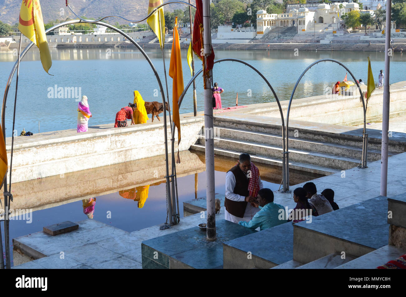 Pushkar, Rajasthan, India- 16 Gennaio 2018: Un prist aiutare famiglia indù per eseguire il rituale puja presso la santa di Pushkar Sarovar Foto Stock