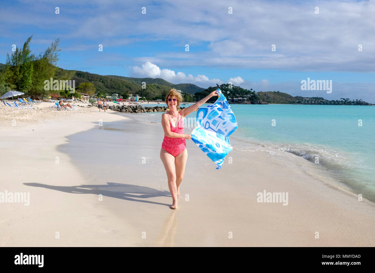 Antigua Piccole Antille isole dei Caraibi West Indies - Bellissima Jolly Harbour spiaggia sabbiosa con la donna in esecuzione con una spiaggia pulita progetta sarong Foto Stock