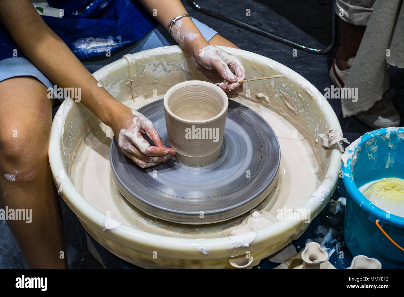 Atelier di ceramica mani coperte con argilla, tornio del vasaio Foto Stock