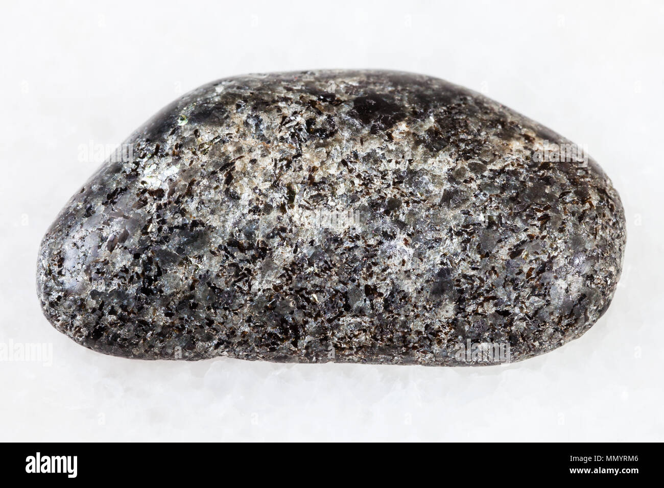 Le riprese in modalità macro di roccia naturale campione - lucidato peridotiti pietra con phlogopite mica su marmo bianco sfondo dalla regione Kovdor, penisola di Kola Foto Stock