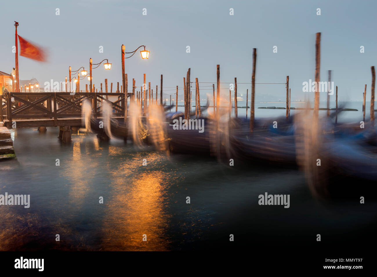 Una lunga esposizione foto di molte gondole vicino al molo in legno a Venezia da twilight Foto Stock