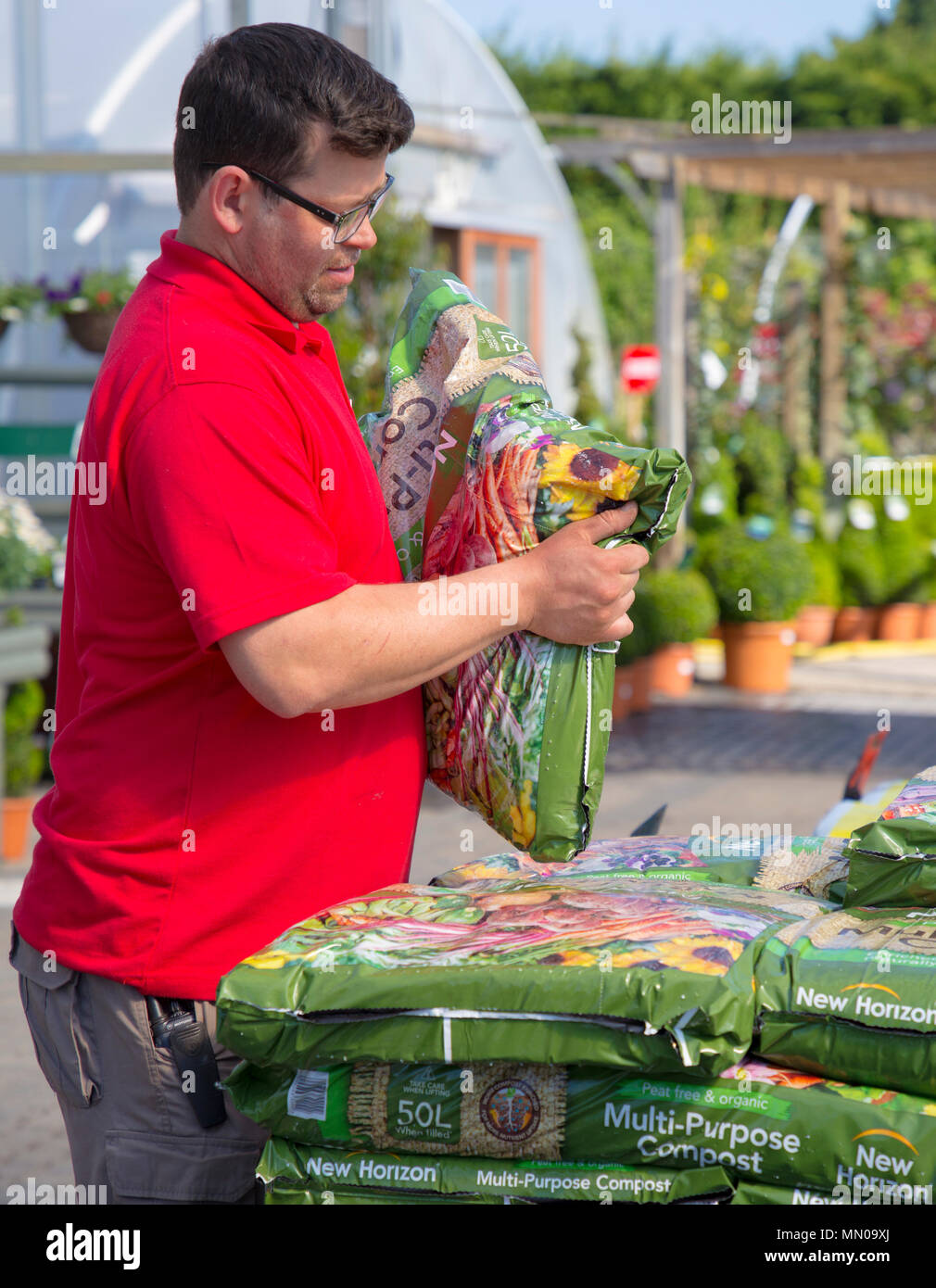 Centro giardino personale di impilamento di sacchetti di compost per la vendita in una serra Foto Stock