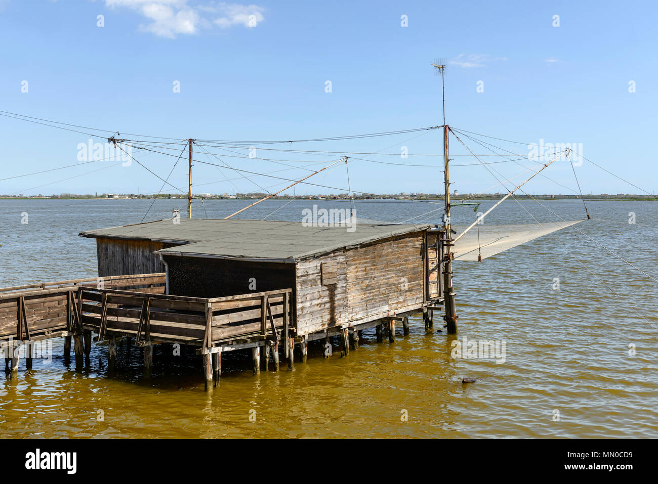 Vista sulla laguna con tradizionale stilt pesca capanna, girato in primavera luminoso della luce del sole a Comacchio, Ferrara, Italia Foto Stock