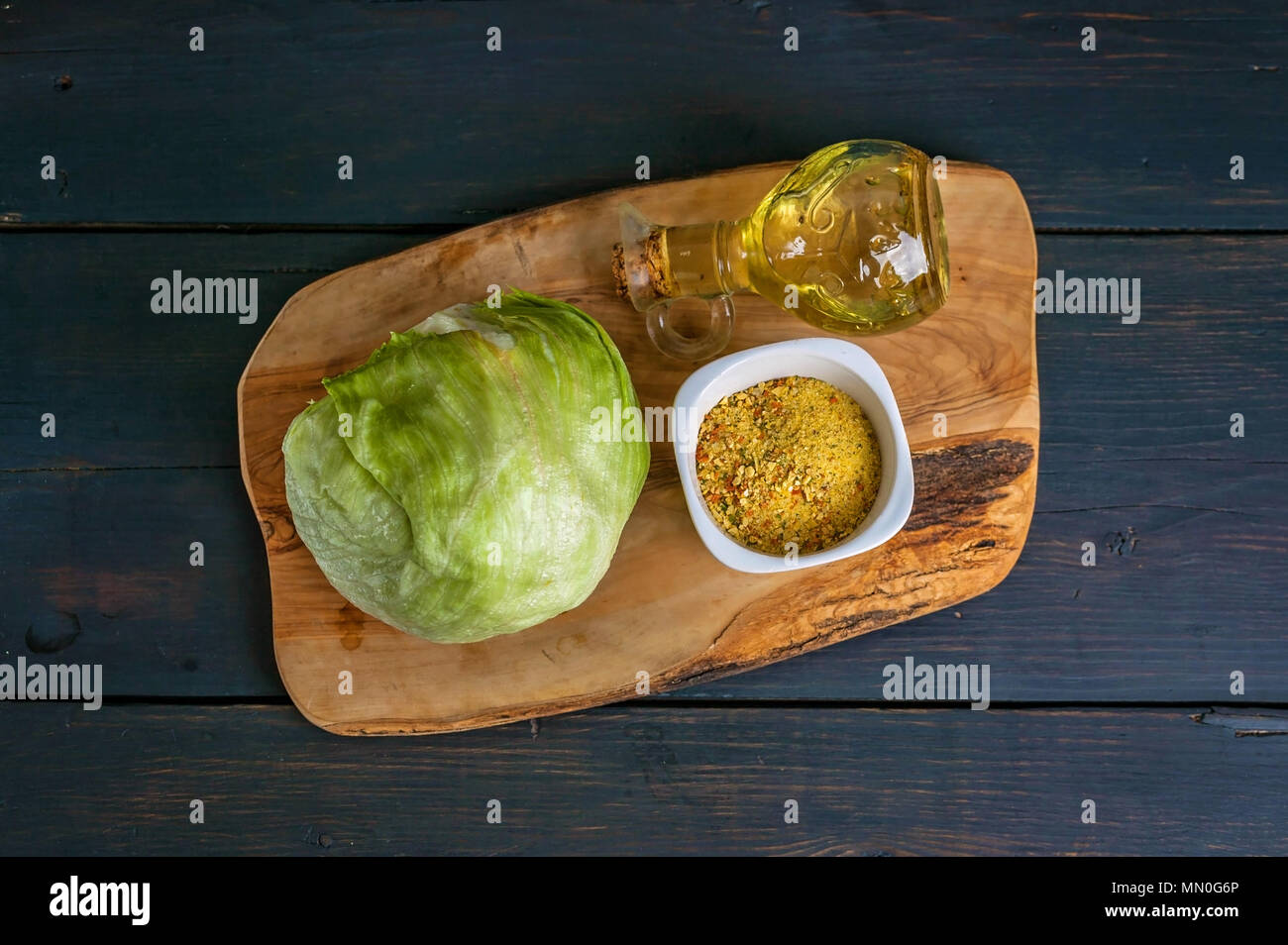 Insalata di ghiaccio, spezie e olio di oliva su un tagliere. Vista superiore Foto Stock