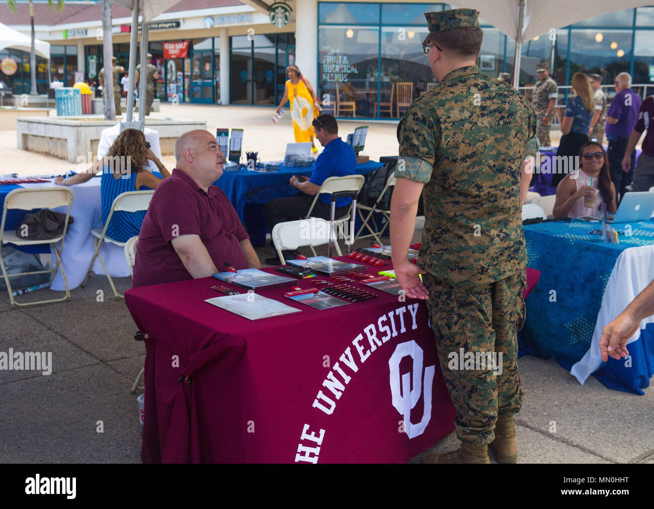 Eric Ludvig, il direttore del sito per l'Università di Oklahoma, condivide la conoscenza degli Stati Uniti ad un Il parco marino Mokapu Mall durante l'istruzione Expo a bordo Marine Corps base Hawaii, 3 agosto 2017. Marines, marinai, coniugi e DoD dipendenti hanno visitato più di 20 tabelle per imparare circa collegio corsi disponibili dopo il lavoro e/o lezioni on-line. Questo è uno dei molti servizi che il Centro educativo prevede active duty i membri del servizio, familiari, veterani, e DoD civili sulla base di assistere all'avvio o il completamento di viaggi verso un diploma di laurea o certificato di programma. (U.S. Marine Corps photo Foto Stock