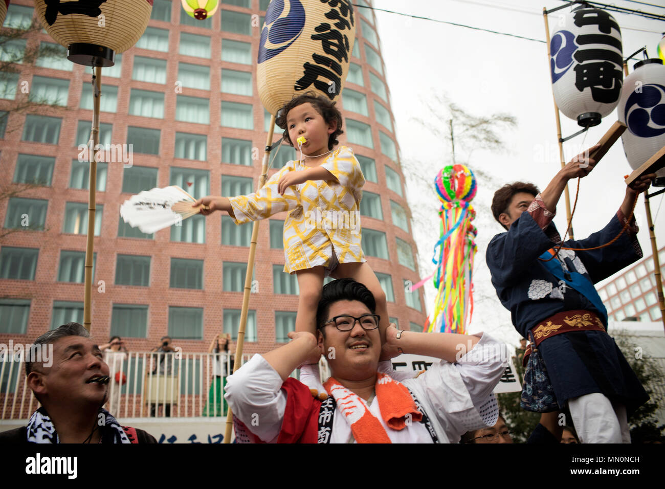 Un bambino aiuta a dirigere persone che trasportano un mikoshi o shirine portatile, sessantasettesima Fussa annuale Festival Tanabata a Fussa City, Giappone, e il Agosto 4, 2017. In molti punti durante la parata mikoshi, i vari gruppi che portano mikoshi farebbe aumentare i santuari. (U.S. Air Force foto di Yasuo Osakabe) Foto Stock