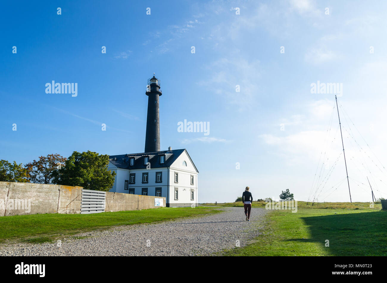 Una donna cammina verso il faro di Sõrve in Saaremaa, Estonia Foto Stock