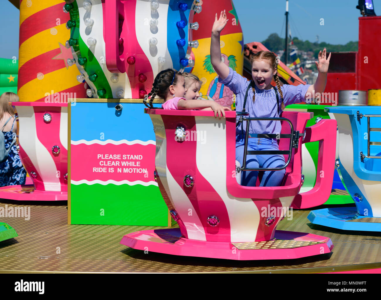 Le tre ragazze godendo di un parco di divertimenti tazzina ride. Foto Stock