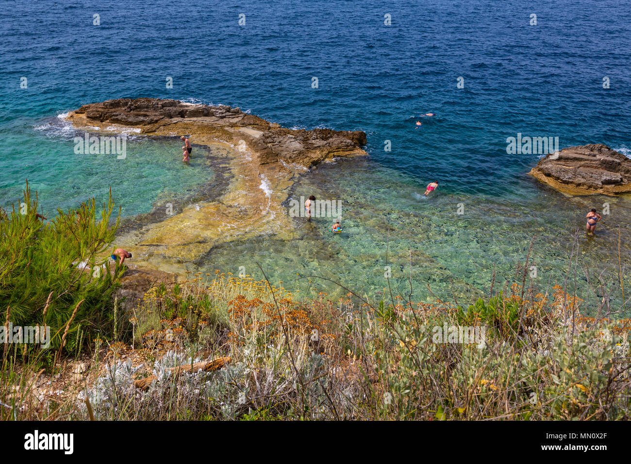 Persone Su Una Spiaggia Rocciosa A Pola Punta Verudela