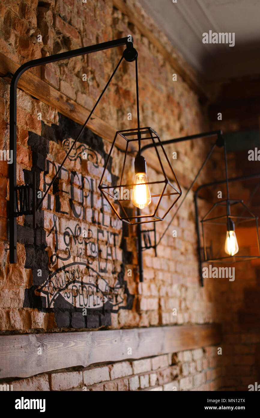 Muro di mattoni con lampade in straordinaria cafe. Foto Stock