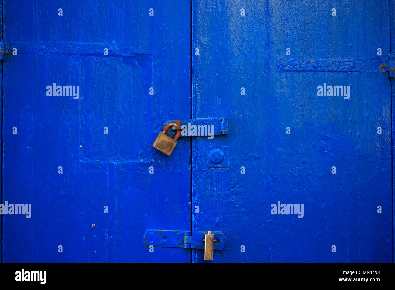 Blu in legno sfondo porta bloccata con due lucchetti arrugginiti. Vecchio, ingresso chiuso fornisce la sicurezza e la privacy. Vista ravvicinata con i dettagli. Foto Stock