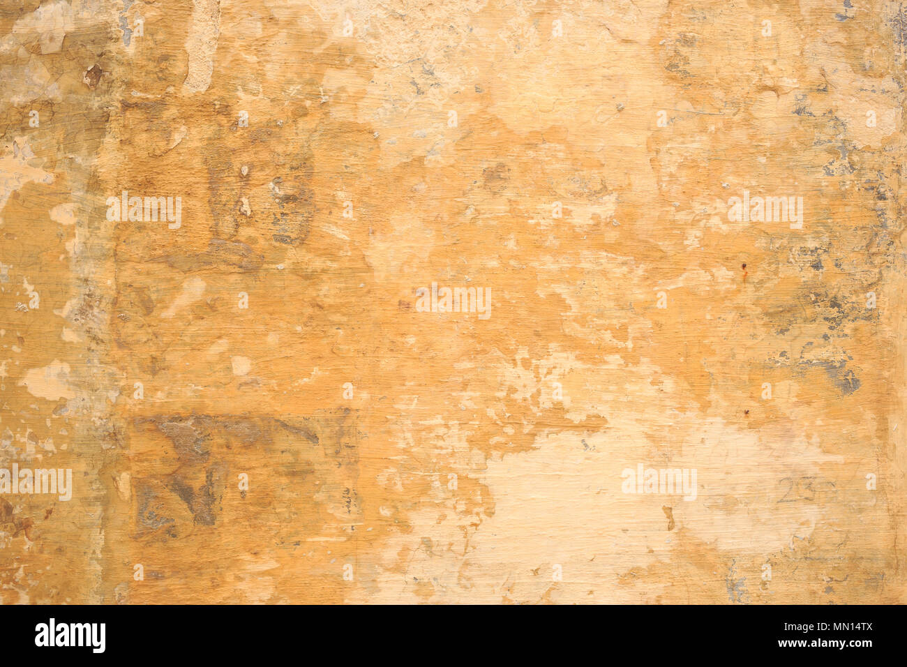 Weathered dipinte di un giallo sullo sfondo della parete, parzialmente sbiadito. Corroso, sbucciate, vintage, muro grezzo per sfondo. Vista ravvicinata con i dettagli. Foto Stock