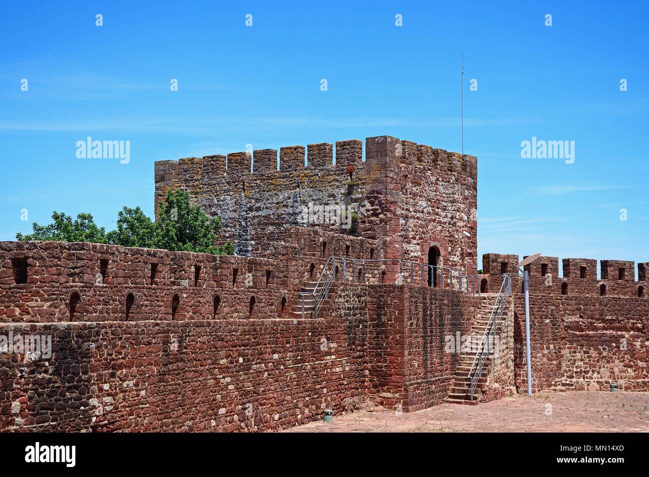 Vista di una parte del castello medievale di merlature e una delle torri, Silves, del Portogallo, dell'Europa. Foto Stock