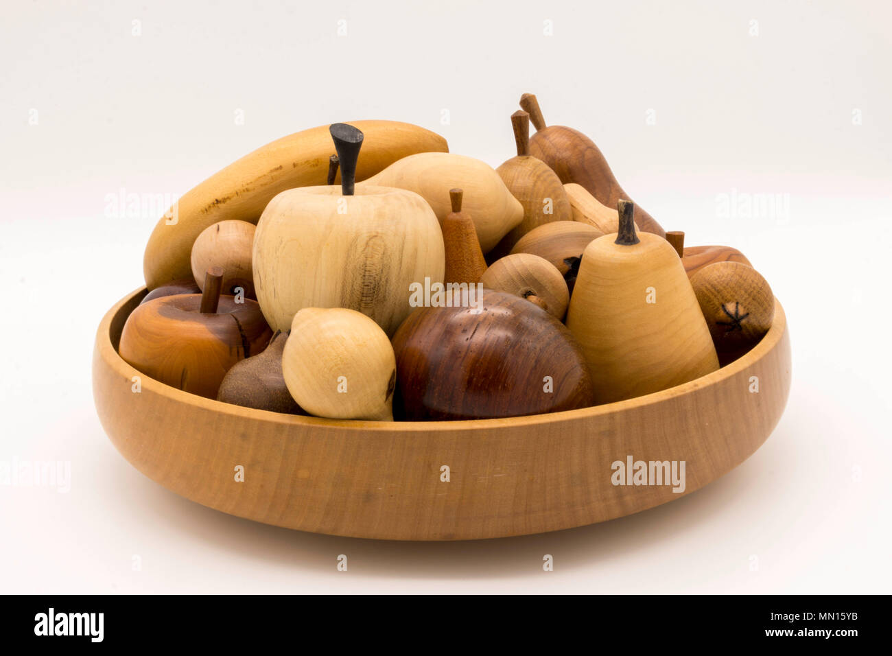 Una selezione di motivi decorativi in legno intagliato frutta su sfondo bianco Foto Stock