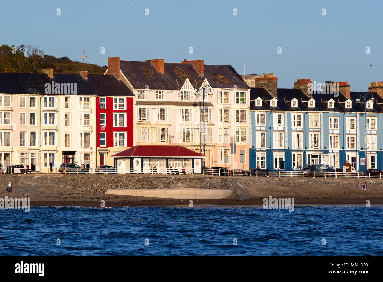 Aberystwyth, Ceredigion, Wales, Regno Unito 13 maggio 2018 UK Meteo: la gente fuori e circa lungo Aberystwyth Beach e dal lungomare con un cielo azzurro e sole questa sera, come si vede da cardigan bay. © Ian Jones/Alamy Live News. Foto Stock