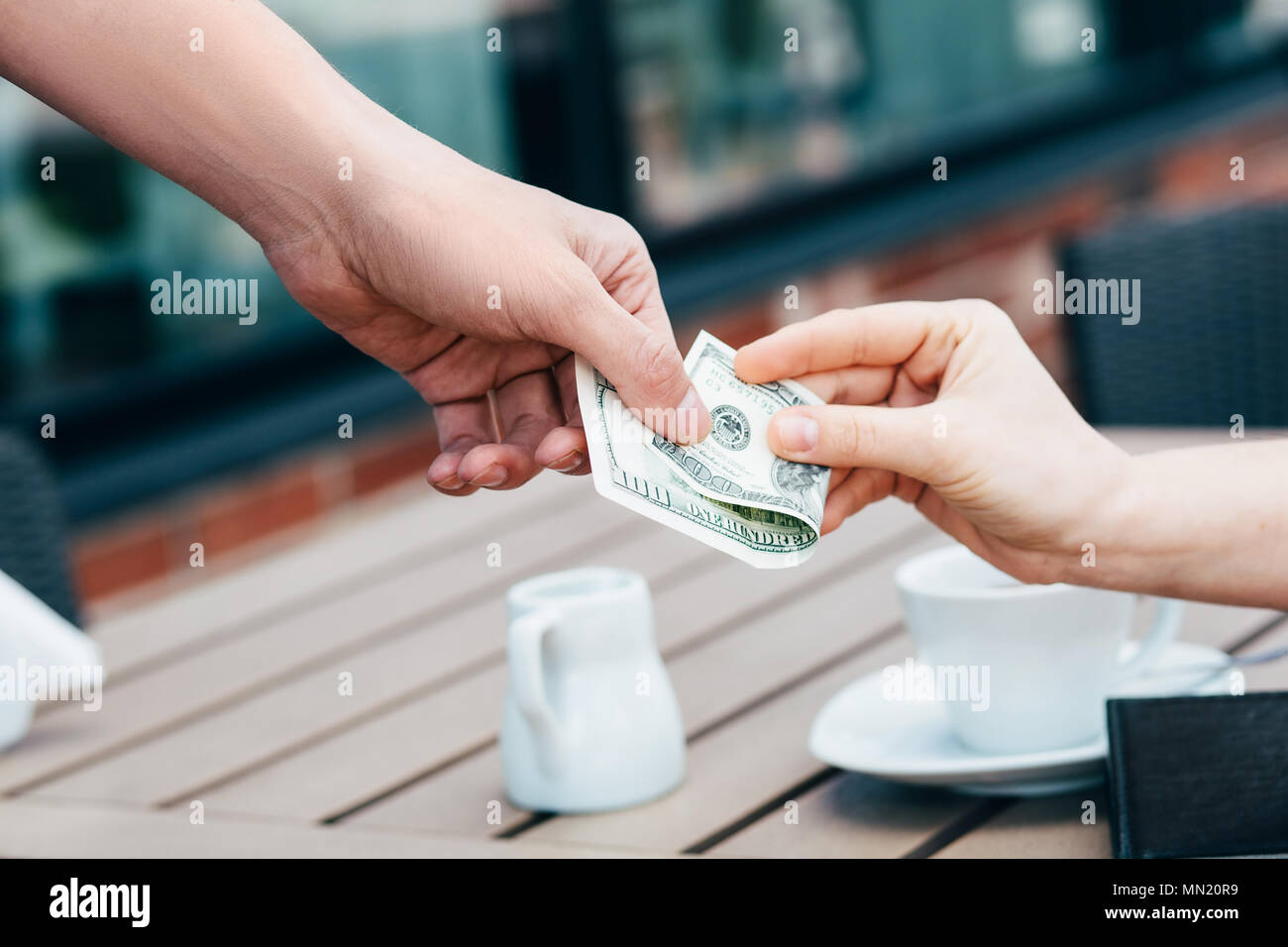 Pagando con dollari note in un cafe, close-up Foto Stock