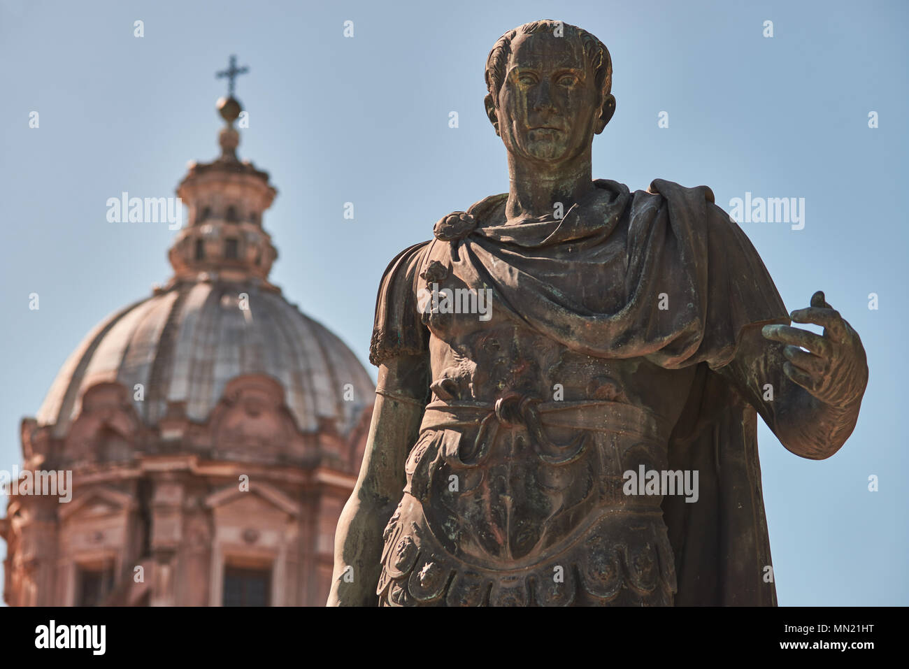 Roma, la statua in bronzo di imperatore Giulio Cesare e sullo sfondo la cupola dei Santi Luca e Martina Chiesa Foto Stock