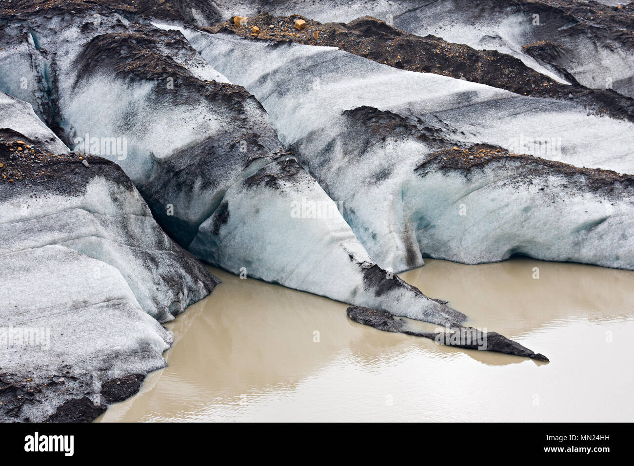 La fine di una lingua del ghiacciaio in acqua sporca, Islanda. Foto Stock