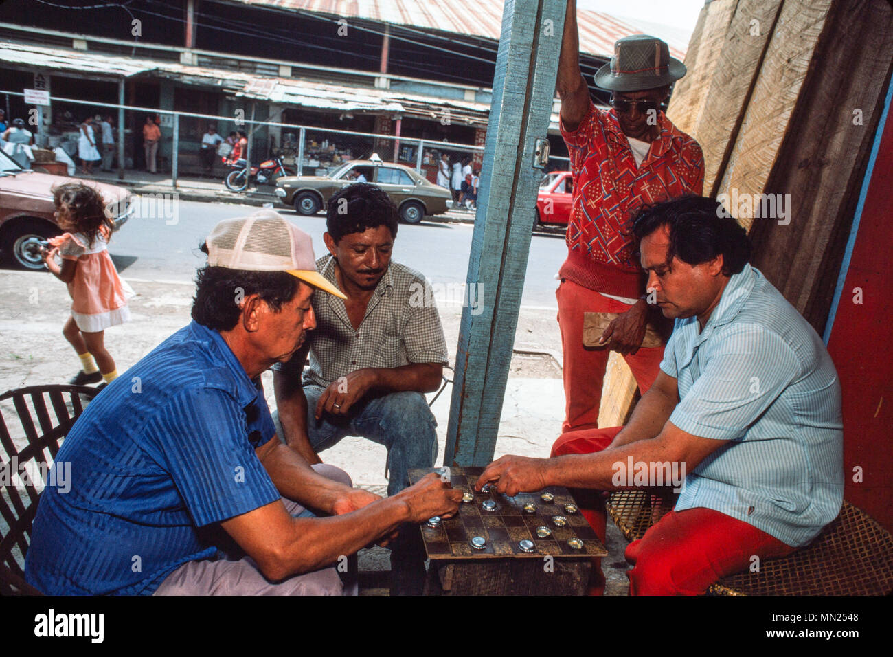 Managua, Nicaragua, Giugno 1986. Il mercato orientale, il più grande mercato del capitale - gli uomini giocano a dama con un bordo. Foto Stock