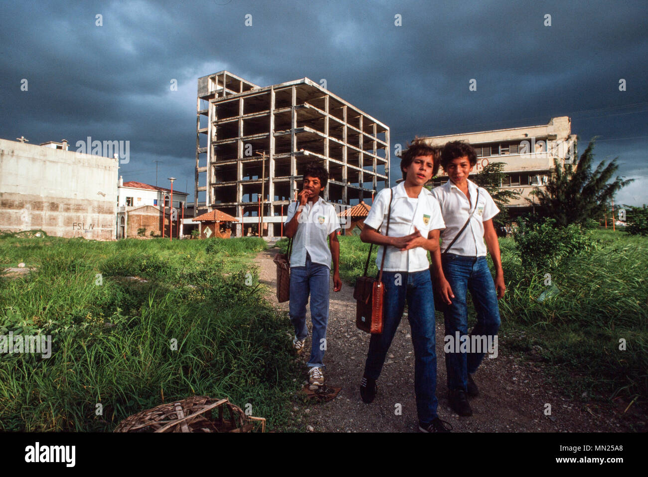 Managua, Nicaragua, giugno 1986; scuola i ragazzi sul loro modo a casa da scuola come aria di tempesta nel centro di Managua. Foto Stock