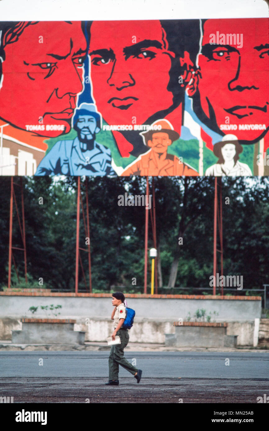 La persona con zaino passa davanti a un grande murale raffigurante figure rivoluzionarie in un ambiente all'aperto. Foto Stock