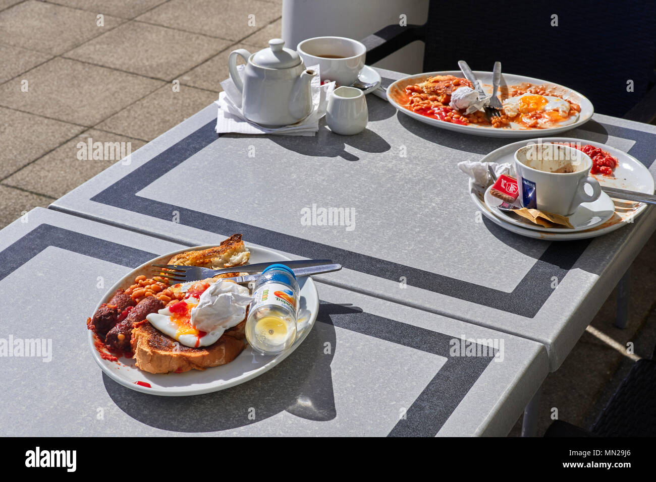Colazioni incompiuto lasciato su un outdoor cafe tabella Foto Stock