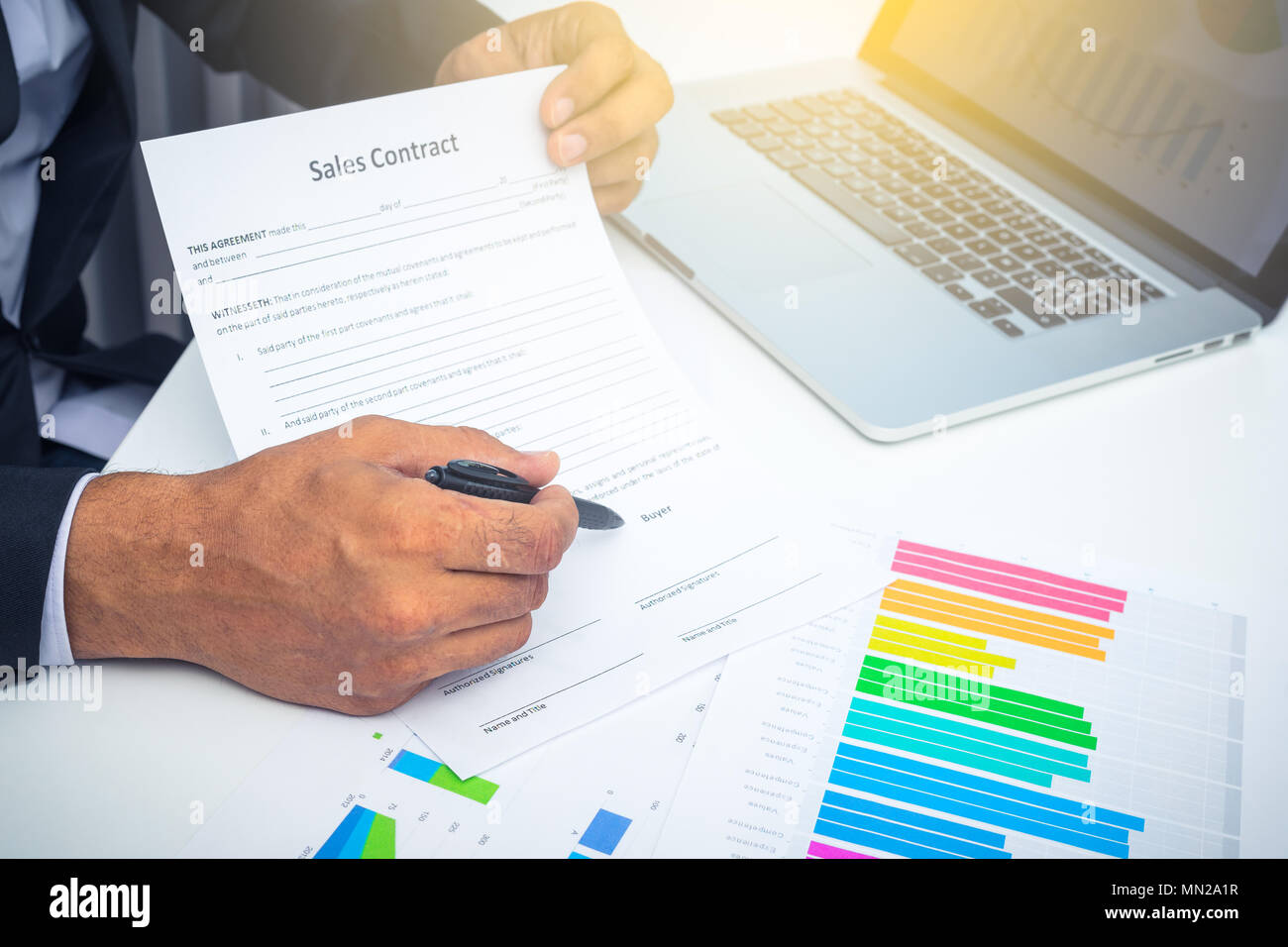 Azienda giovane agente ha mostrato il contratto di vendita e lo si punta verso la scrivania in ufficio Foto Stock