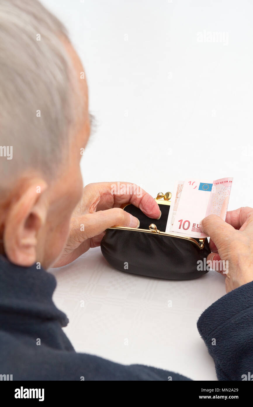 Donna senior in possesso di una borsa vuota e una decina di banconote in euro nelle sue mani., copia o lo spazio di testo, di vecchiaia il concetto di povertà Foto Stock
