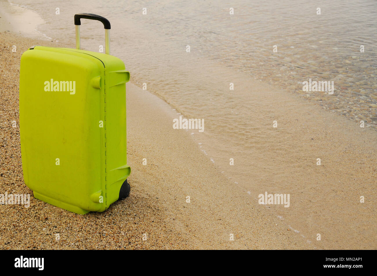 Valigia sulla spiaggia sabbiosa Foto Stock