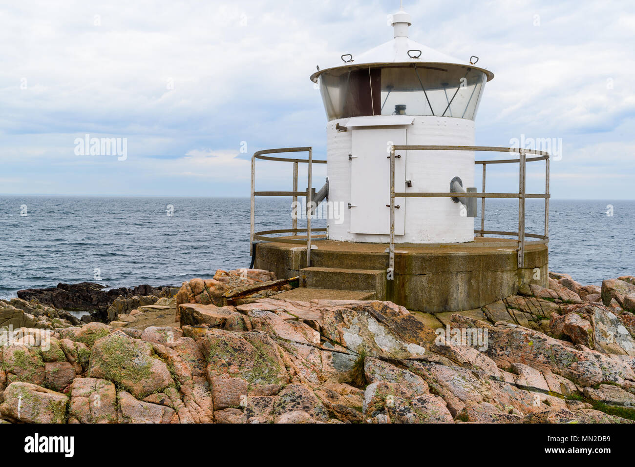 Western Kullaberg riserva naturale, Svezia - il piccolo faro bianco Kullen ovest alla fine di una scogliera costiere dal mare. Foto Stock