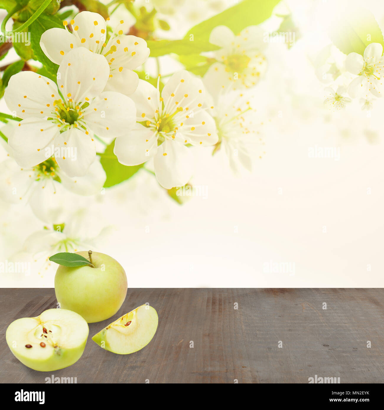 Molla di messa a fuoco morbida dello sfondo con apple frutta, foglie, fiori e grigio vuoto pannello di legno Foto Stock