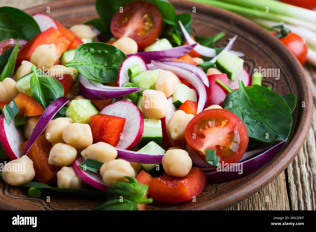 Chickpears e verdura fresca insalata in vaso di ceramica, sano pasto vegano su tavola in legno rustico Foto Stock