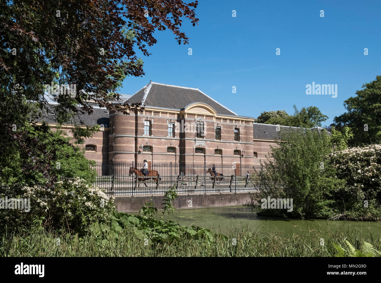 Cavalieri fuori le Scuderie Reali edificio (Koninklijke Stallen), visto dal giardino del palazzo (Paleistuin), l'Aia, Paesi Bassi. Foto Stock