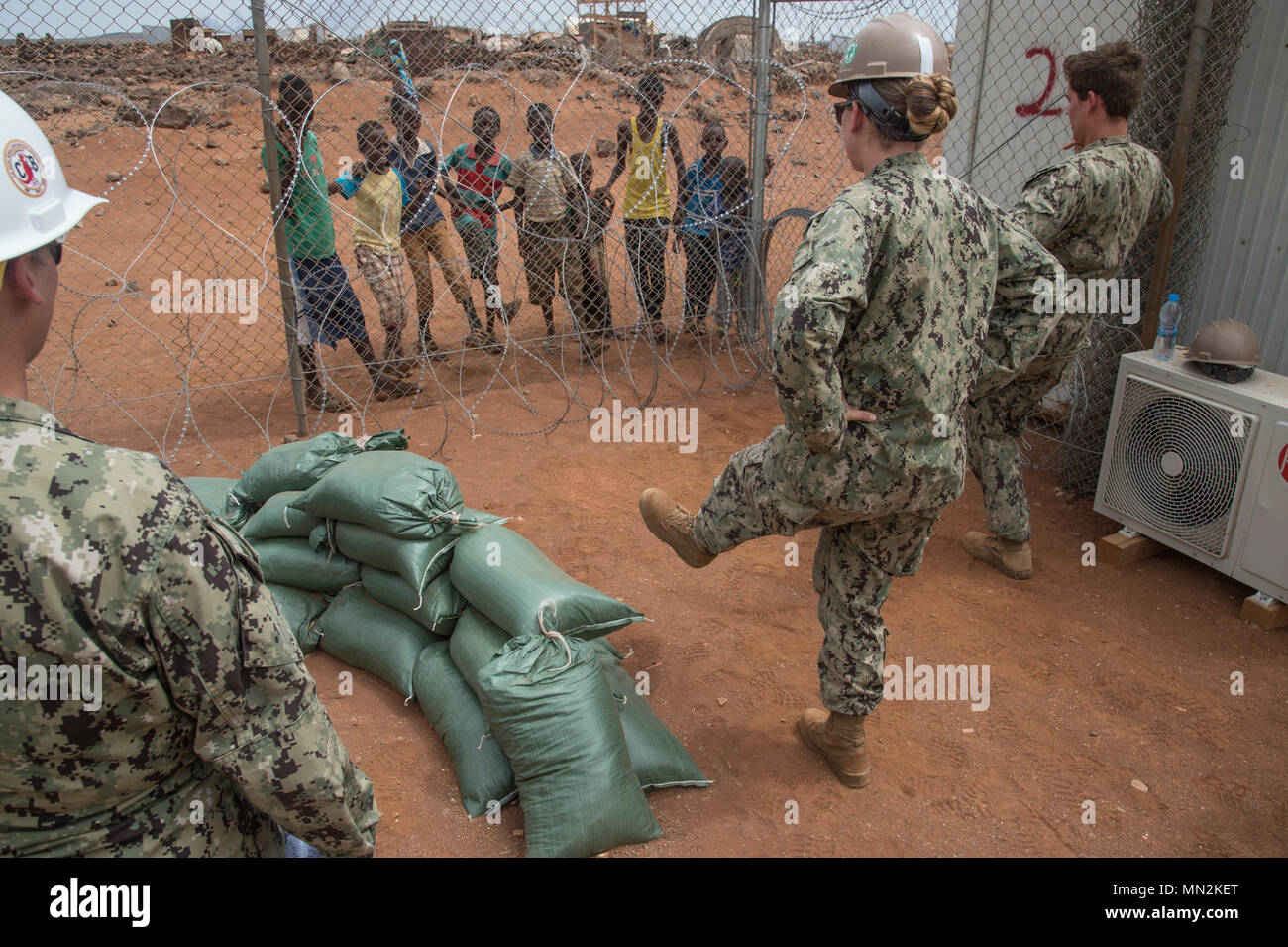 Stati Uniti Navy Seabees Petty Officer di terza classe Lacy P'Piscina e sottufficiali di terza classe Cayla George assegnato a Combined Joint Task Force-Horn dell Africa fare l'Hokey carina con bambini locali su un sito in costruzione nella regione di Arta, Gibuti, dove essi sono la costruzione di un centro medico, e il agosto 17, 2017. Il progetto è stato avviato da Naval Mobile Battaglione di costruzione uno (NMCB 1) e viene scaricata dal NMCB 133 che continuerà a lavorare sul progetto con piani di completamento nel 2018. (U.S. Air National Guard foto di Tech. Sgt. Joe Harwood) Foto Stock