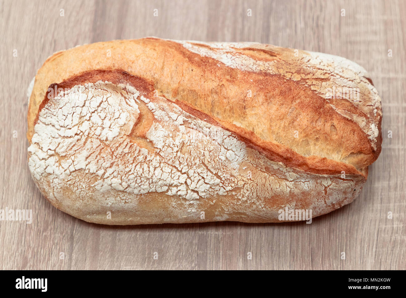 Delizioso pane cotto su una luce sullo sfondo di legno Foto Stock