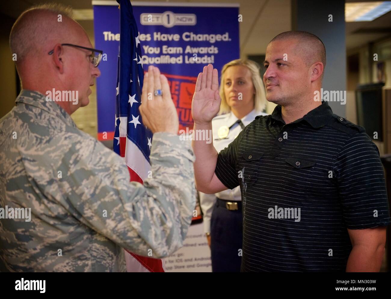 932Nd Airlift Wing Capo degli affari pubblici, Lt. Col. Stan Paregien sorge dalla bandiera americana ed esegue il giuramento di arruolamento per Brian chinoni, chi ha arruolato nella United States Air Force Reserve e la 932nd Airlift Wing a Scott Air Force Base, Illinois. La cerimonia ha avuto luogo nel mese di agosto 4, 2017, in 932nd AW e la sede è stata facilitata dal lavoro di sfondo del reclutatore Tech. Sgt. Nikki Seibel, visto qui testimoniare il prossimo appuntamento di chinoni. Per gli altri operatori che sono interessati a partecipare possono contattare l'ufficio di reclutamento a (618)-229-7077 o numero verde 1-800-257-1212. (U.S. Aria Fo Foto Stock