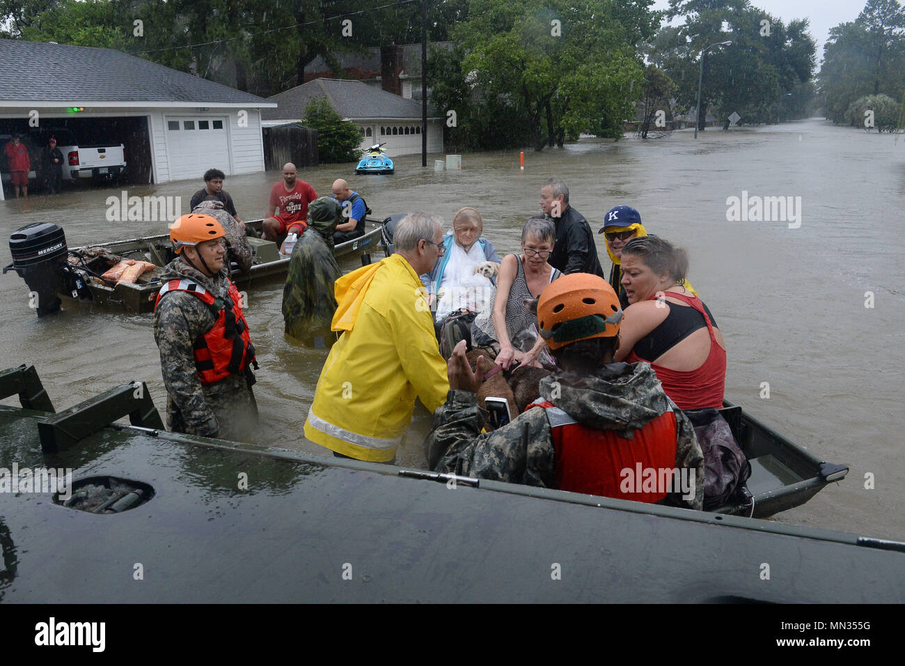 Texas guardie nazionali dall'ingegnere 386Battaglione lavorare al fianco dei primi responder da Texas Task Force One e il Cypress Creek dei Vigili del fuoco per il soccorso di cittadini locali da gravi inondazioni in Cypress Creek, 28 agosto 2017. Soldati, vigili del fuoco, personale paramedico e vicini garantita più di mille persone e centinaia di cani e gatti sono stati sicuri, evacuarli su terreno asciutto e rifugi locale. (U.S. Esercito nazionale Guard foto di Capt. Martha Nigrelle) Foto Stock