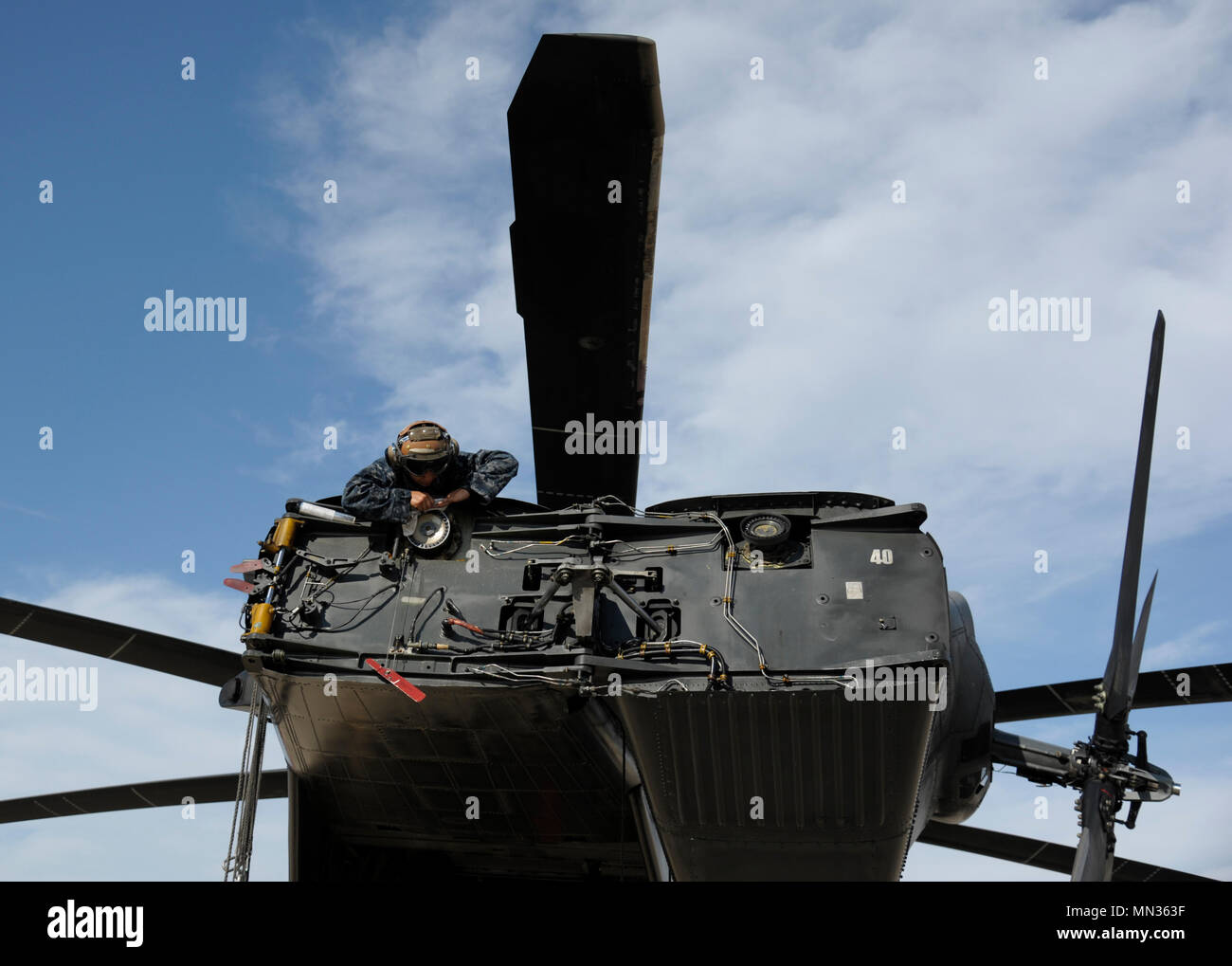 Stati Uniti Navy aviation electronics technician Priscilla Hernandez, assegnato per le avanguardie di elicottero di contromisure Mine Squadron (HM) 14, pulisce e ispeziona il Rotary di un MH-53 elicottero in preparazione per le operazioni di soccorso dopo l'uragano Harvey Agosto 28, 2017 a Naval Air Station giunto di base riserva di Fort Worth, Texas. Uragano Harvey fatto approdo nel sud-est della Texas, portando a registrare le inondazioni e distruzione per la regione. I militari Usa attività supportate FEMA nonché delle autorità statali e locali di salvataggio e di soccorso. (U.S. Air Force photo by Staff Sgt. Ian Hoachlander) Foto Stock